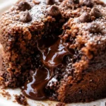 Rich gooey chocolate cake with molten center in a small ramekin, topped with powdered sugar.