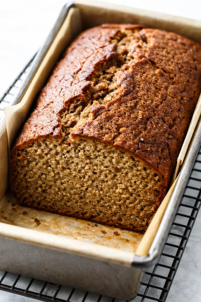 Moist gluten-free banana bread slice with golden brown crust and visible walnuts, a healthy and delicious treat.