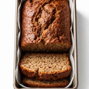 Mixing gluten-free banana bread batter with mashed bananas, resulting in a smooth and moist texture.