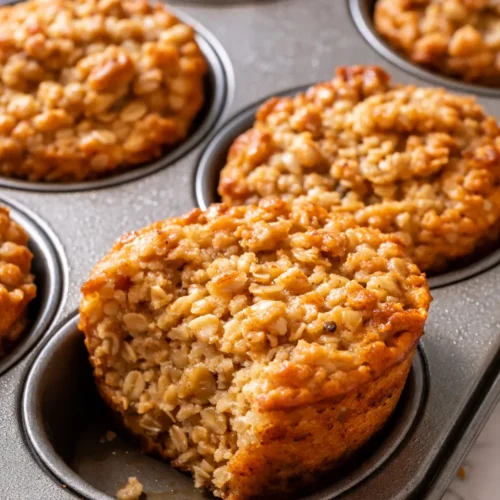 Golden baked oatmeal cups with crispy edges and soft centers, displayed on a rustic plate.