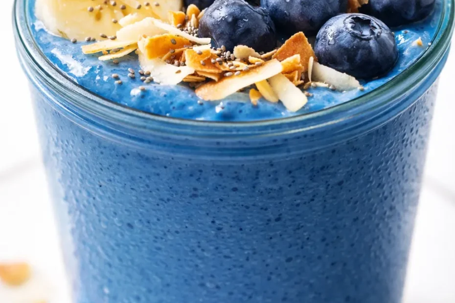 Vibrant blue smoothie bowl topped with fresh berries, sliced banana, granola, and a drizzle of coconut cream, creamy and inviting texture.