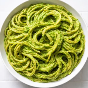 Blending fresh herbs and cream into a vibrant green sauce for creamy pasta, showing the smooth texture and bright color.