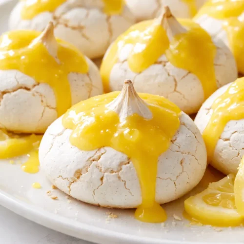 Shatteringly crisp mini meringues with silky lemon curd, golden peaks and glossy yellow curd.