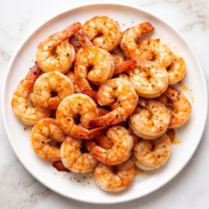 Sautéed shrimp turning pink and juicy in a hot skillet with garlic, herbs, and a splash of lemon juice.