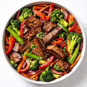 Sizzling beef strips and colorful bell peppers cooking in a wok with glossy sauce, steam rising, vibrant textures.