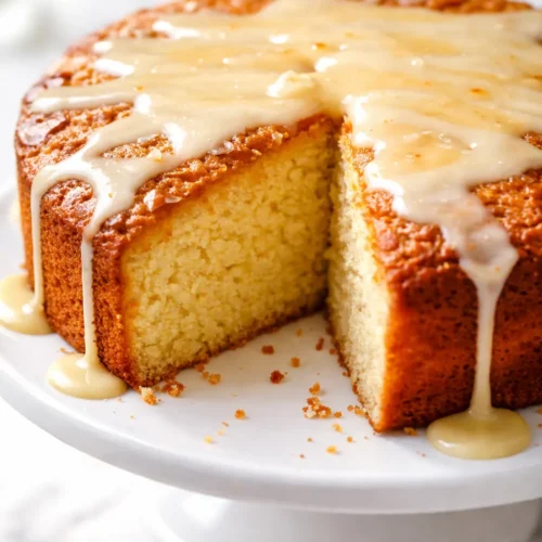 Golden brown butter cornmeal cake with a crisp edge and tender crumb, lightly dusted with powdered sugar.