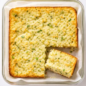 Tender lemon zucchini bars with a crackling glaze, golden crumb, and bright yellow zest.