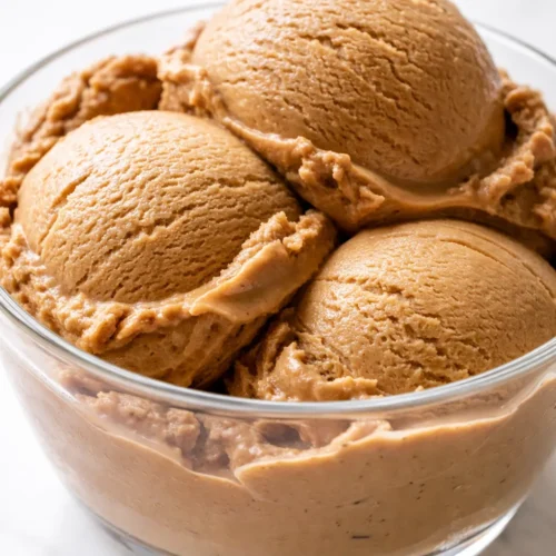 Scoop of no-churn bold coffee ice cream with silky texture and deep espresso color, garnished with coffee beans.