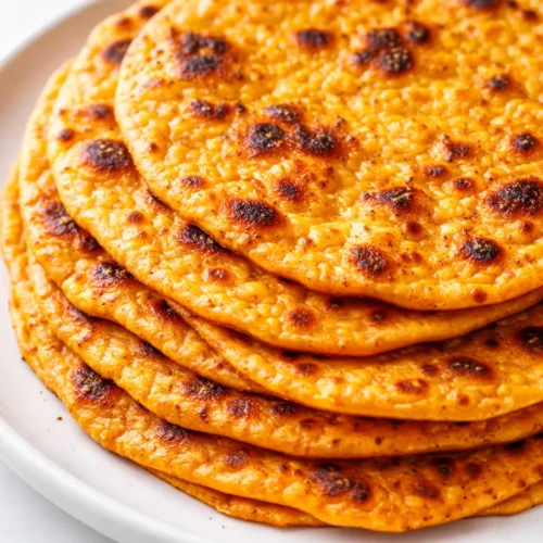 Stack of soft golden orange sweet potato tortillas that stay pliable for days, no dry edges.