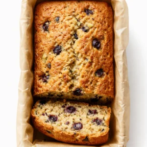 Bowl of blueberry zucchini bread batter packed with fresh blueberries and shredded zucchini, topped with a crackly cinnamon mixture.