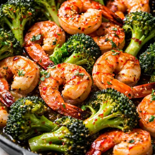 Glossy honey garlic butter shrimp with vibrant green broccoli florets in a savory-sweet sauce.