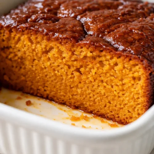 Saftiger Butternut-Kürbiskuchen mit goldbraunen Zimtstreuseln, innen saftig und außen knusprig, auf einem Teller.